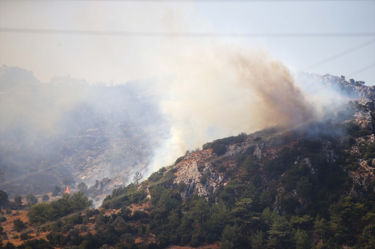 Muğla'nın Menteşe ilçesinde ormanlık alanda çıkan yangına havadan ve karadan müdahale...