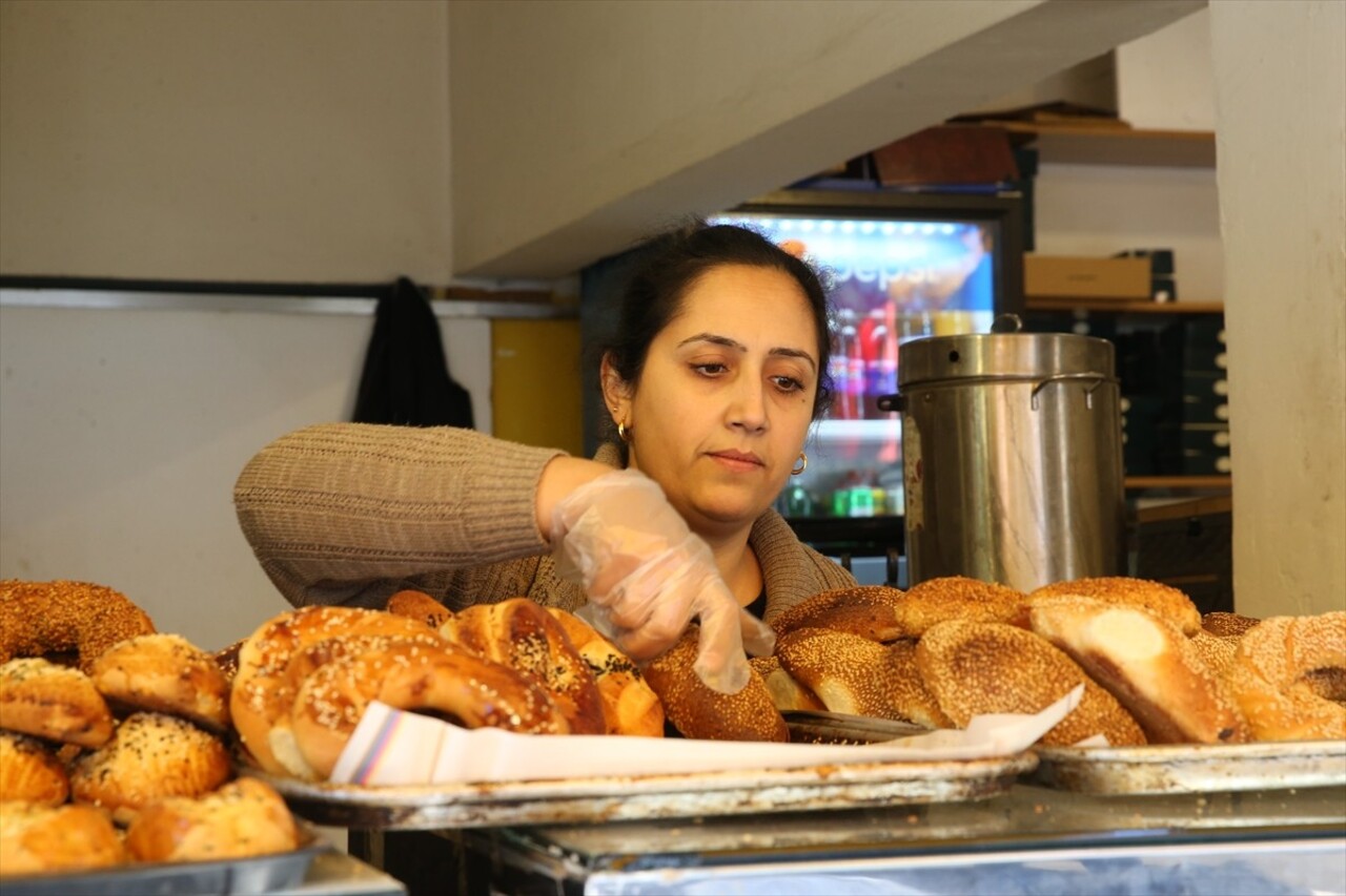 Hatay'ın İskenderun ilçesinde üşümesin diye simit fırınına alınan kadının, iş yerindeki masa...